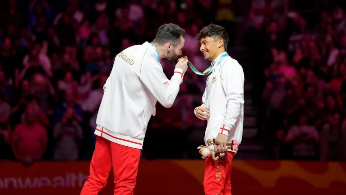 James Hall presses his lips to Jake's gold after a fierce competition in Men's Individual All Round Artistic Gymnastics